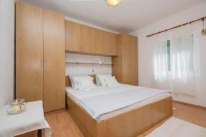 a bedroom with a large bed with wooden cabinets at Nika Vacation House in Zavojane +18 photos
