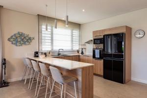 a kitchen with a counter and a island with stools at Asmara Alora E3 - Beachfront in Rivière Noire