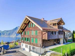 a large wooden house with green shutters at Apartment Bärgli in Krattigen in Krattigen