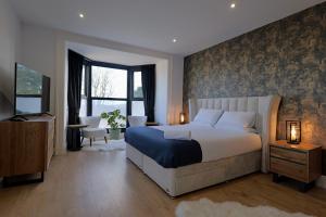a bedroom with a large bed and a television at The Tall Trees Hotel in Amlwch