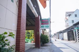 a building with a sign on the side of a street at Nhà Nghỉ Hiếu Thuận in Nhơn Trạch