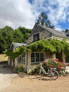 a bike parked in front of a house at Domaine du moulin de la plaine in Trôo