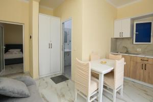 a kitchen with a white table and chairs in a room at Villa Evelyn Free Parking in Vlorë +196 photos