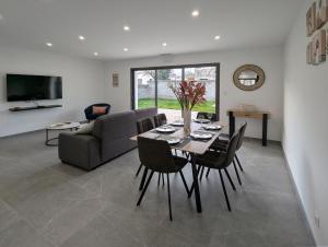 a living room with a table and chairs and a couch at home family in Chasseneuil-du-Poitou
