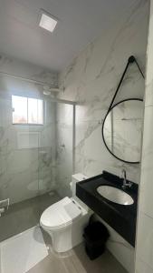 a bathroom with a toilet and a sink and a mirror at Hotel Rota Dos Tropeiros in Castro +45 photos