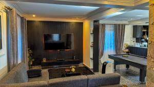 a living room with a couch and a flat screen tv at Hide Out Lake Villa Uganda in Bwerenga
