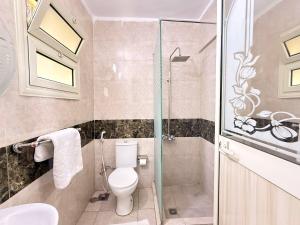 a bathroom with a toilet and a glass shower at Moon Homes in Downtown Cairo in Cairo +53 photos