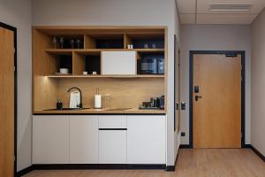 a kitchen with white cabinets and a sink at TULIP Residences Lviv in Lviv