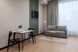 a living room with a couch and a table and chairs at TULIP Residences Lviv in Lviv