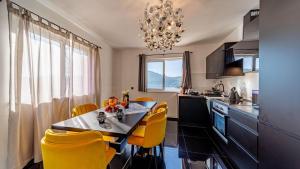 a kitchen with a dining table and yellow chairs at Villa Franka by Villas Guide in Vela Luka