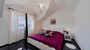 a bedroom with a bed with purple sheets and a window at Villa Franka by Villas Guide in Vela Luka +29 photos