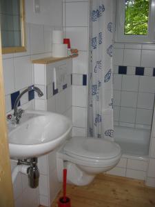 uma casa de banho com um lavatório, um WC e uma banheira em B&B Am Büel em Sevelen