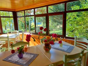 a dining room with a table with flowers on it at pensiunea Gabriela in Durău