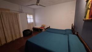 a bedroom with a blue bed and a window at Casa en Claromecó in Balneario Claromecó