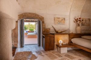 a bedroom with a bed and a door to a patio at Masseria De Li Travaj - Rive del Salento in Patù