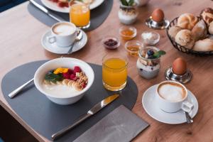a table with a bowl of cereal and a bowl of fruit at MyLiving - Hotel B&B by Majestic Resorts Dolomites in San Lorenzo di Sebato
