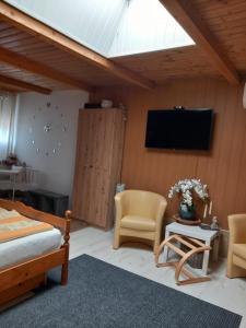 a bedroom with a bed and two chairs and a tv at BpR P3 Lodge Apartment with A/C in Budapest