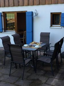 a table and chairs in front of a building at Meisters Ferienhaus in Lechbruck