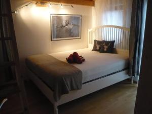 a teddy bear sitting on a bed in a bedroom at Meisters Ferienhaus in Lechbruck