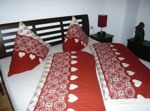 two red and white pillows on a bed at Meisters Ferienhaus in Lechbruck