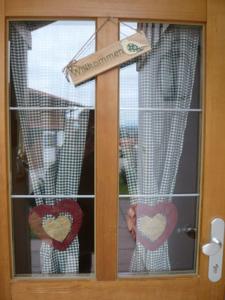 a door with hearts on it with a sign on it at Meisters Ferienhaus in Lechbruck