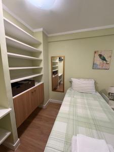 a bedroom with a bed and a mirror at Ipê Rosa Apartamento in Brasília