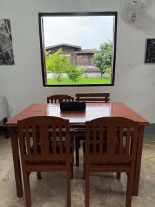 a dining room table with two chairs and a window at Baboo Studio in Chiang Dao