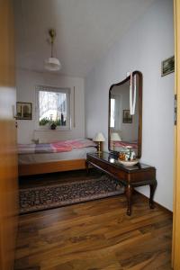 a bedroom with a bed and a mirror and a table at Haus Hönigblick in Wilnsdorf