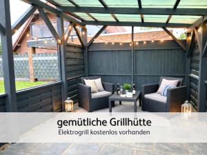 a pergola with two chairs and a table at strandnahe Familien-Oase mit Kinderbuggy in Bensersiel +64 photos