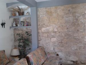a living room with two chairs and a stone wall at RC - Alcobaça Villa in Alcobaça