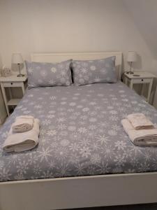 a bed with two pillows and towels on it at Craigmile Cottage in Fraserburgh