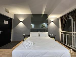 a bedroom with a large white bed with towels on it at Metra Square Ayer Keroh MITC in Ayer Keroh