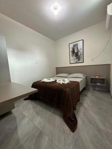 a bedroom with a bed with a blanket on it at Suíte Cavalos - Queen's Hotel in Formosa