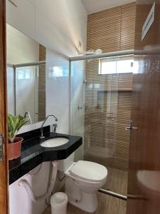 a bathroom with a toilet and a sink and a shower at Suíte Cavalos - Queen's Hotel in Formosa +74 photos