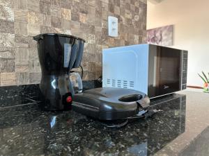 a blender sitting on a counter next to a microwave at Suíte Cavalos - Queen's Hotel in Formosa