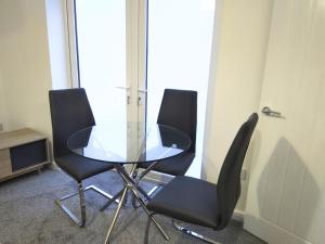 a glass table and four chairs in a room at Sigma Executive Apartment 5 in South Shields