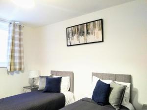 a bedroom with two beds and a picture on the wall at Sigma Executive Apartment 5 in South Shields