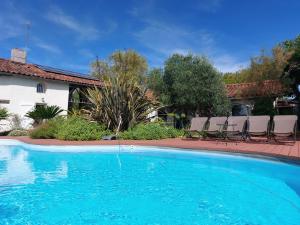 a swimming pool with chairs and a house at Le Clos de Saint Amour in Montauban