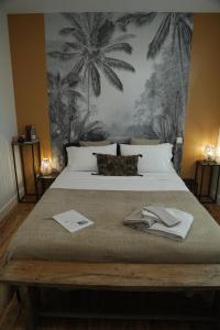 a bedroom with a large bed with palm trees on the wall at Maison Farol in Salles