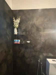 a bathroom with a black wall with a vase of flowers at Lagoon View Mawella Villa in Tangalle