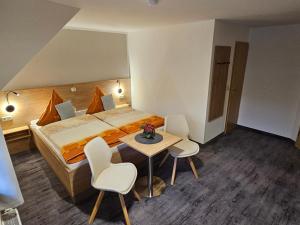 a hotel room with a bed and a table and chairs at Pension Edelstein in Ostseebad Sellin