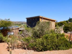 a building in the middle of a desert with bushes at Black Sunbird Retreat in Heidelberg