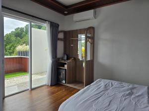 a bedroom with a bed and a large window at Probosiwi Resort Syariah in Talunombo