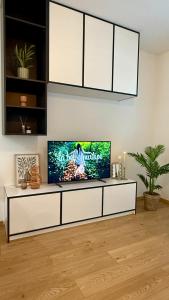 a living room with a flat screen tv on a white cabinet at Prosperity Apartment s parkovaním in Žilina