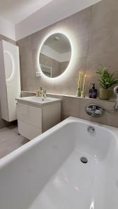a bathroom with a tub and a sink and a mirror at Prosperity Apartment s parkovaním in Žilina +14 photos