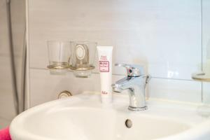 a bathroom sink with a toothbrush holder and a faucet at Casa Sybille, beautiful lake view in Minusio
