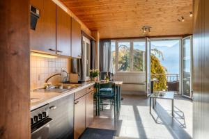 a kitchen with a sink and a table with chairs at Casa Sybille, beautiful lake view in Minusio