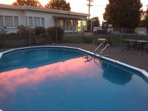 a blue swimming pool in front of a house at Wairoa Motel in Wairoa