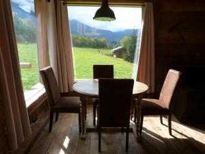a table and chairs in a room with a large window at La Cubelette in Chamonix