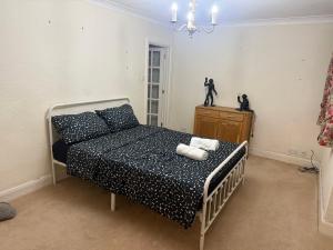 a bedroom with a bed with black and white sheets at The Sweet Spot in Ickenham